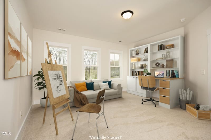 Bright room with light gray sofa, white built-in bookshelves and desk, wooden easel with sketch, and windows with natural light.
